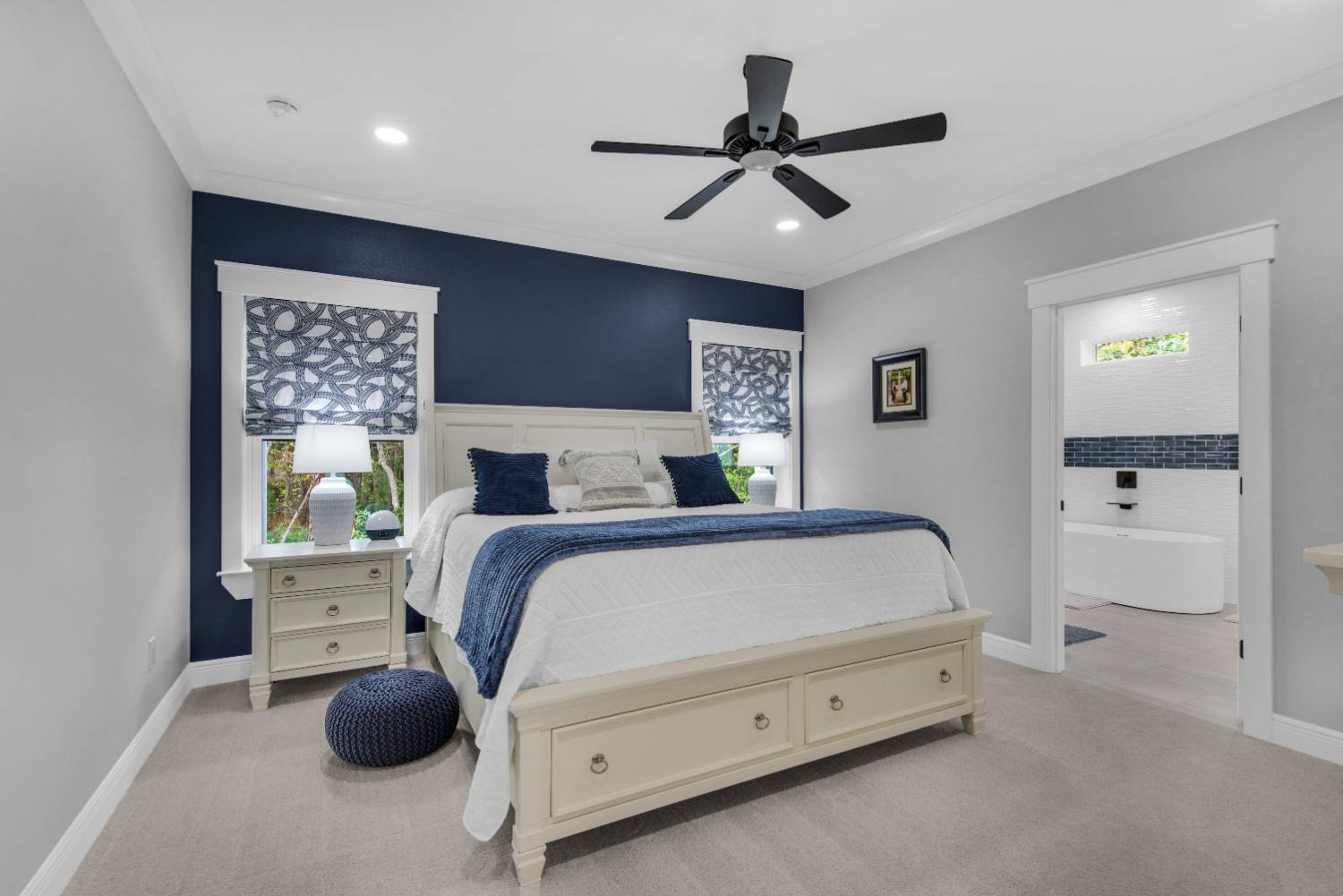 Master bedroom with blue accent wall and modern decor in The Lafon custom home by EZ Modern Homes Pensacola, FL-optimized