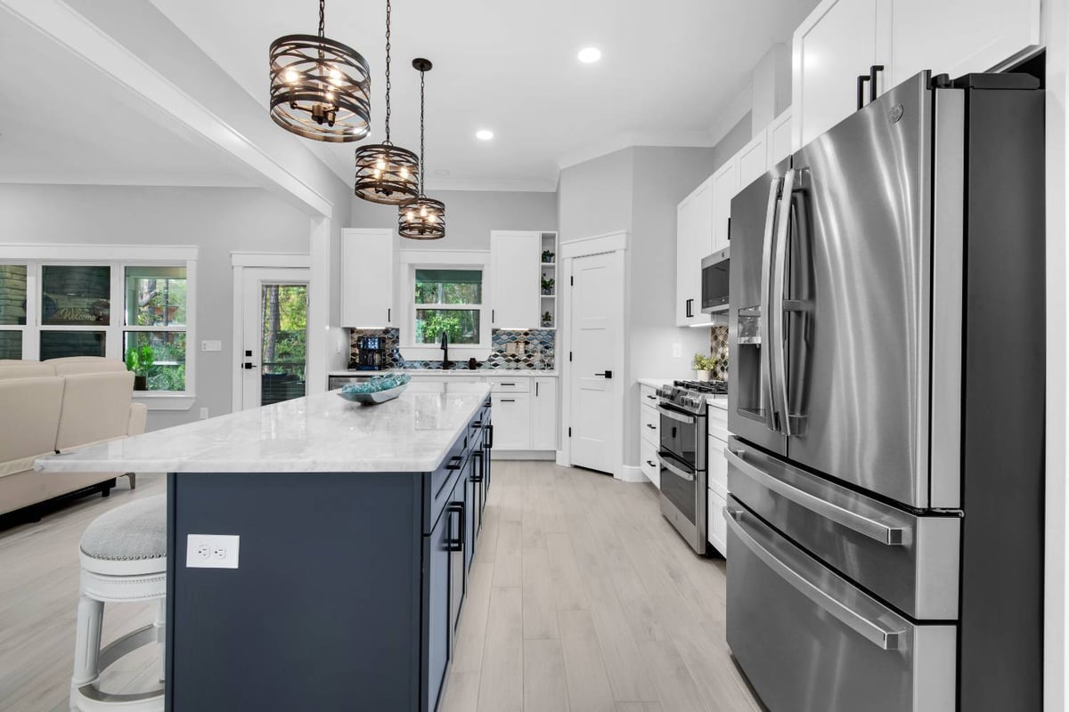 Side view of kitchen island and stainless appliances in The Lafon custom home by EZ Modern Homes Pensacola, FL-optimized