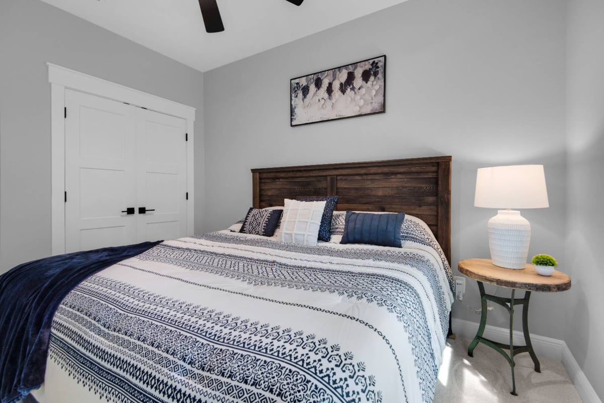 bedroom with wood headboard and bedside lamp in Pensacola custom home by EZ Modern Homes The Lafon-optimized