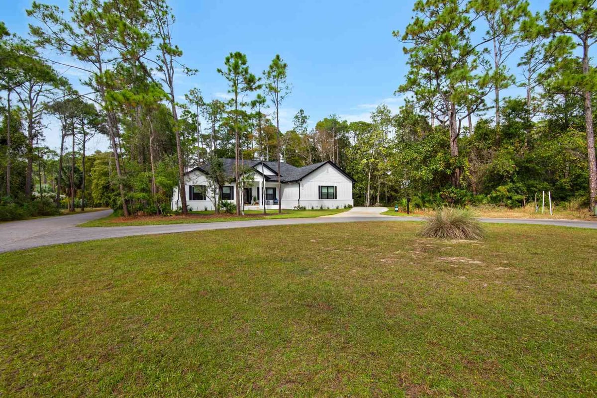 front elevation of custom home with expansive lawn and trees by EZ Modern Homes Pensacola FL The Lafon-optimized-optimized