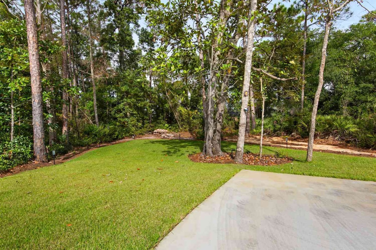 green backyard with trees and planting beds in Pensacola FL custom home by EZ Modern Homes The Lafon-optimized-optimized