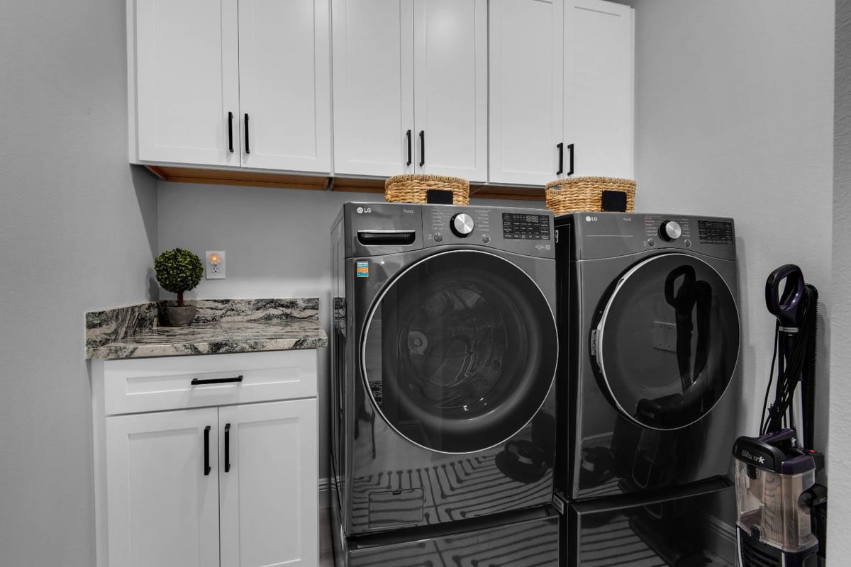 laundry room with built in cabinets and LG washer dryer in Pensacola custom home by EZ Modern Homes The Lafon-optimized