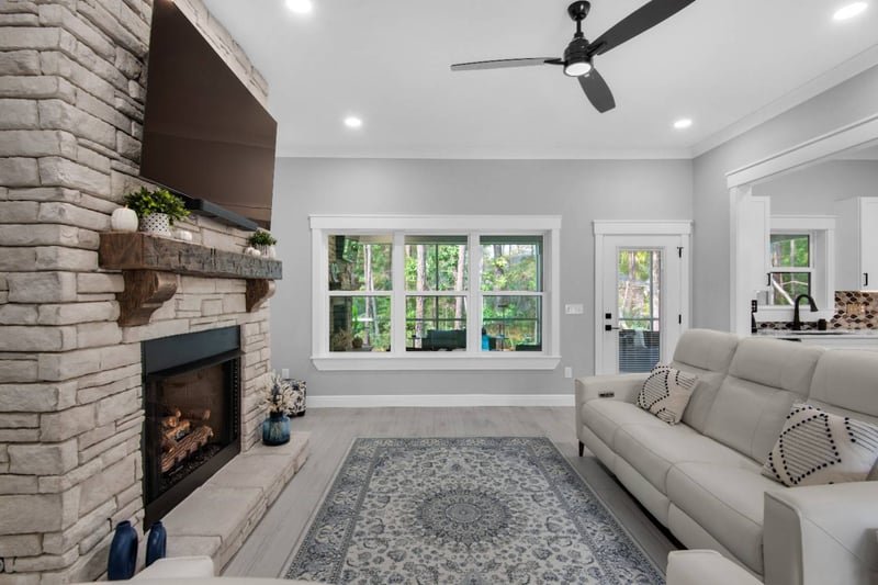 Living room angle showing fireplace and large window view by EZ Modern Homes Pensacola FL The Lafon-optimized