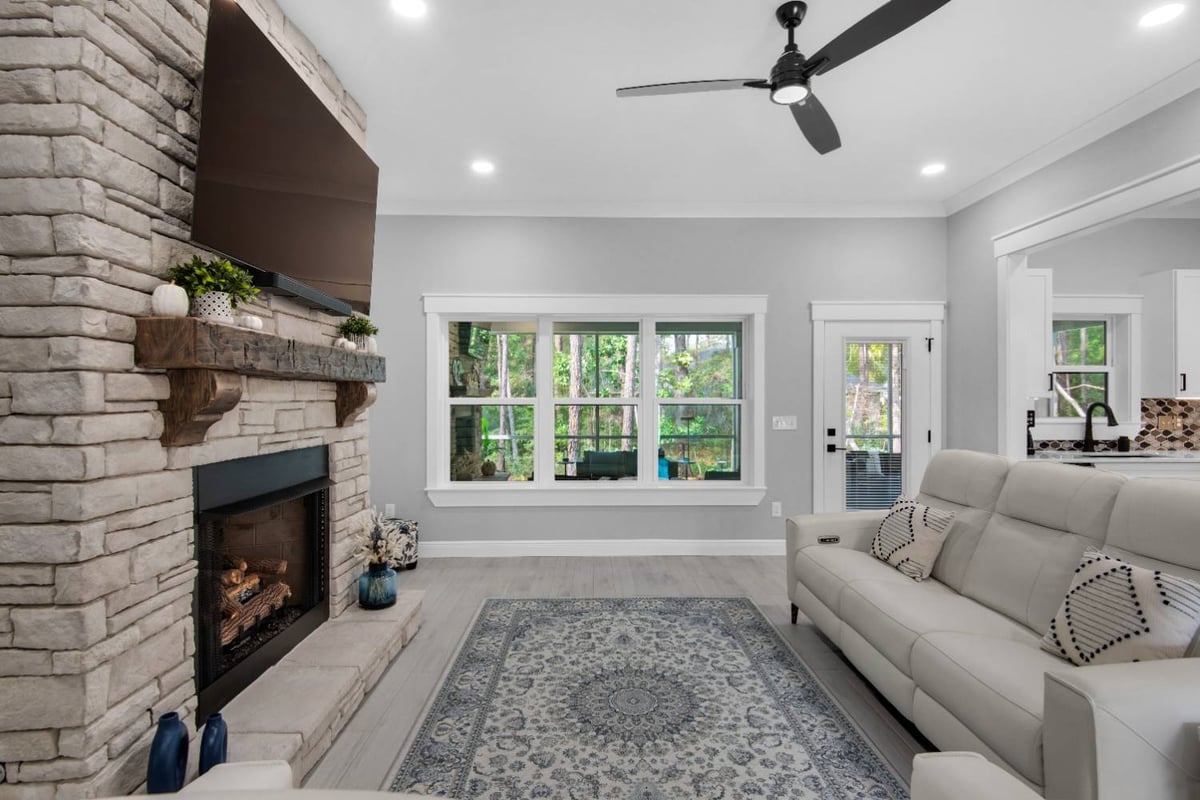living room angle showing fireplace and large window view by EZ Modern Homes Pensacola FL The Lafon-optimized