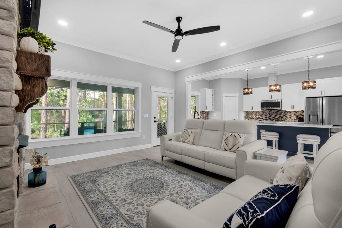 living room with fireplace and seating facing windows by EZ Modern Homes Pensacola FL The Lafon-optimized