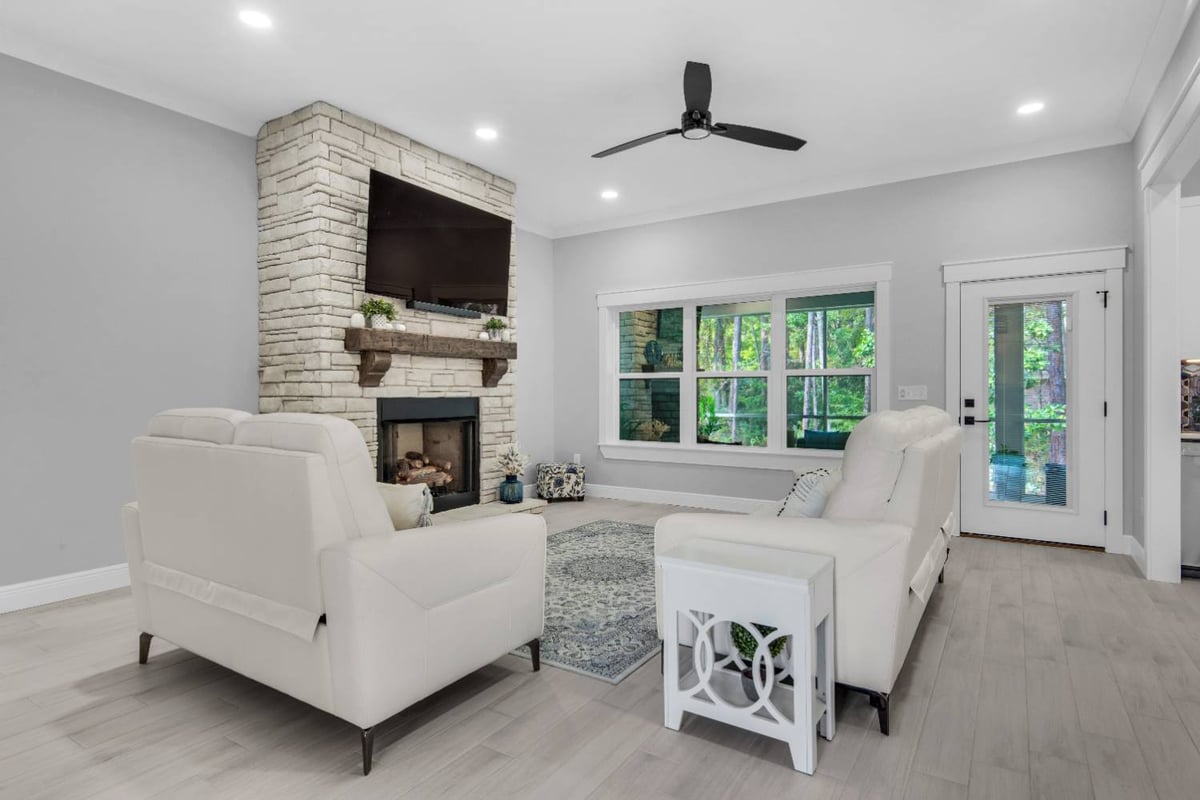living room with stone fireplace and mounted TV by EZ Modern Homes Pensacola FL The Lafon-optimized