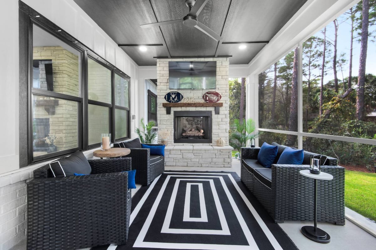 screened porch with fireplace and seating in custom home by EZ Modern Homes Pensacola, FL The Lafon-optimized