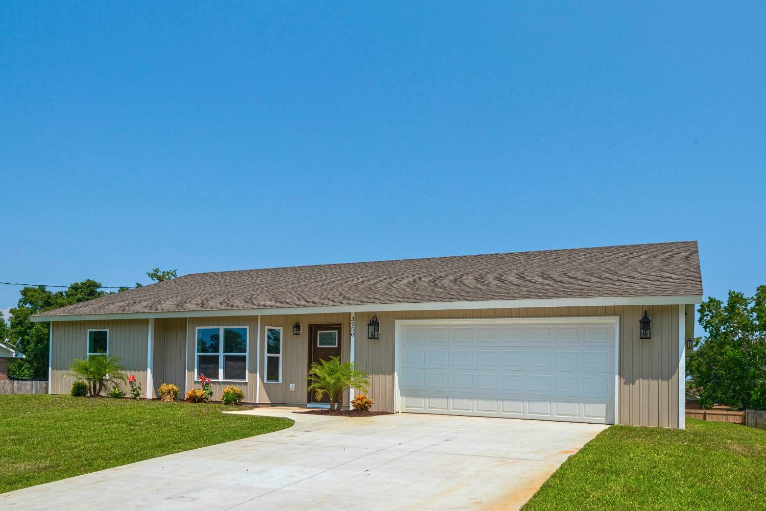 Angled view of custom home exterior with two-car garage by EZ Modern Homes Pensacola FL The Pins-optimized