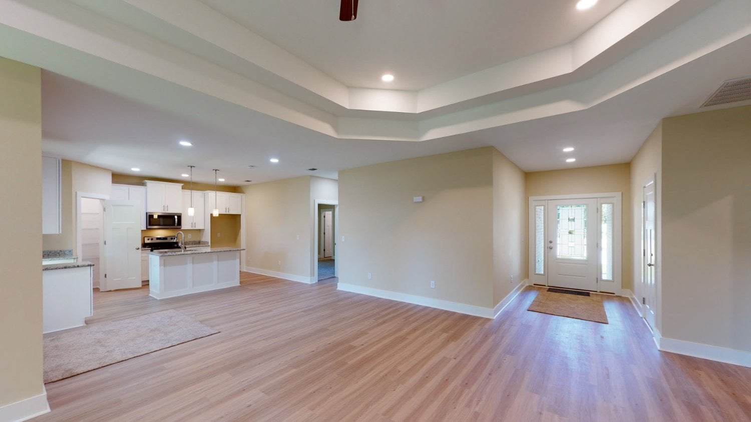 Open living and kitchen layout in a custom home by EZ Modern Homes in Pensacola, FL with modern finishes and wood floors.-optimized