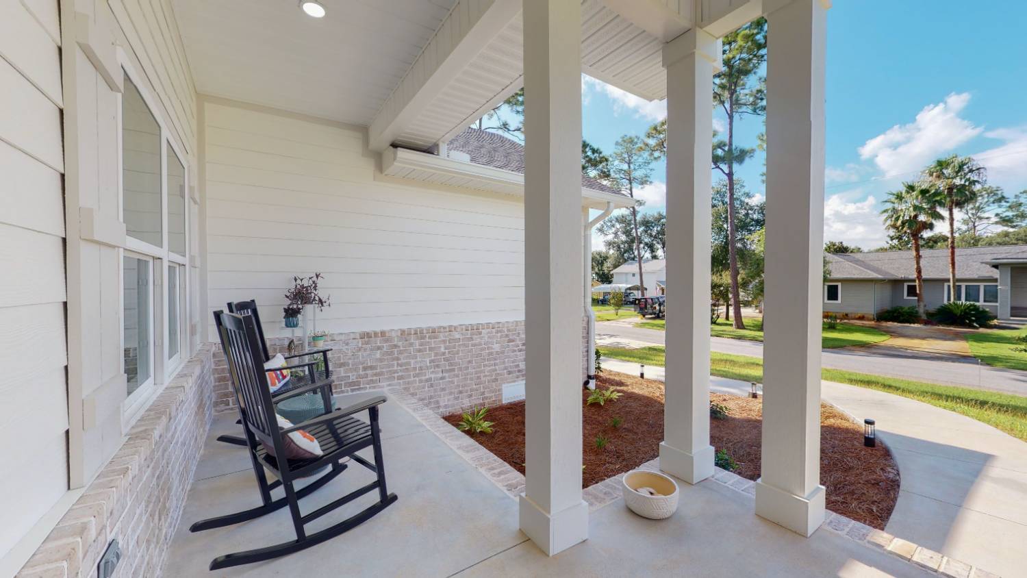 Side porch view of EZ Modern Homes The Lafon custom home with seating area in Pensacola, FL-optimized