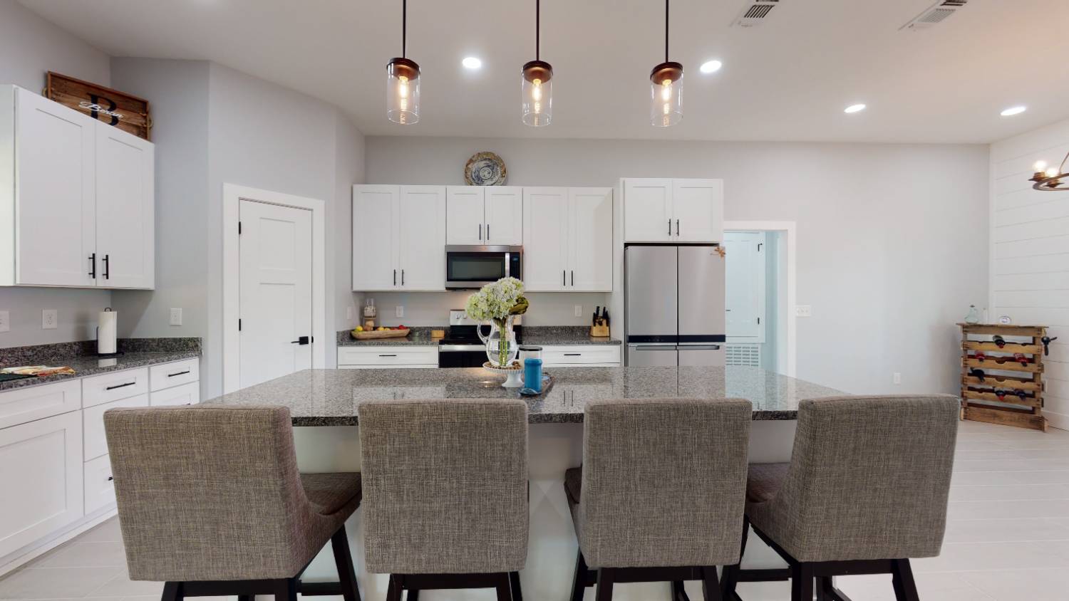 kitchen island with bar stools and pendant lighting in The Lafon custom home by EZ Modern Homes in Pensacola, FL-optimized