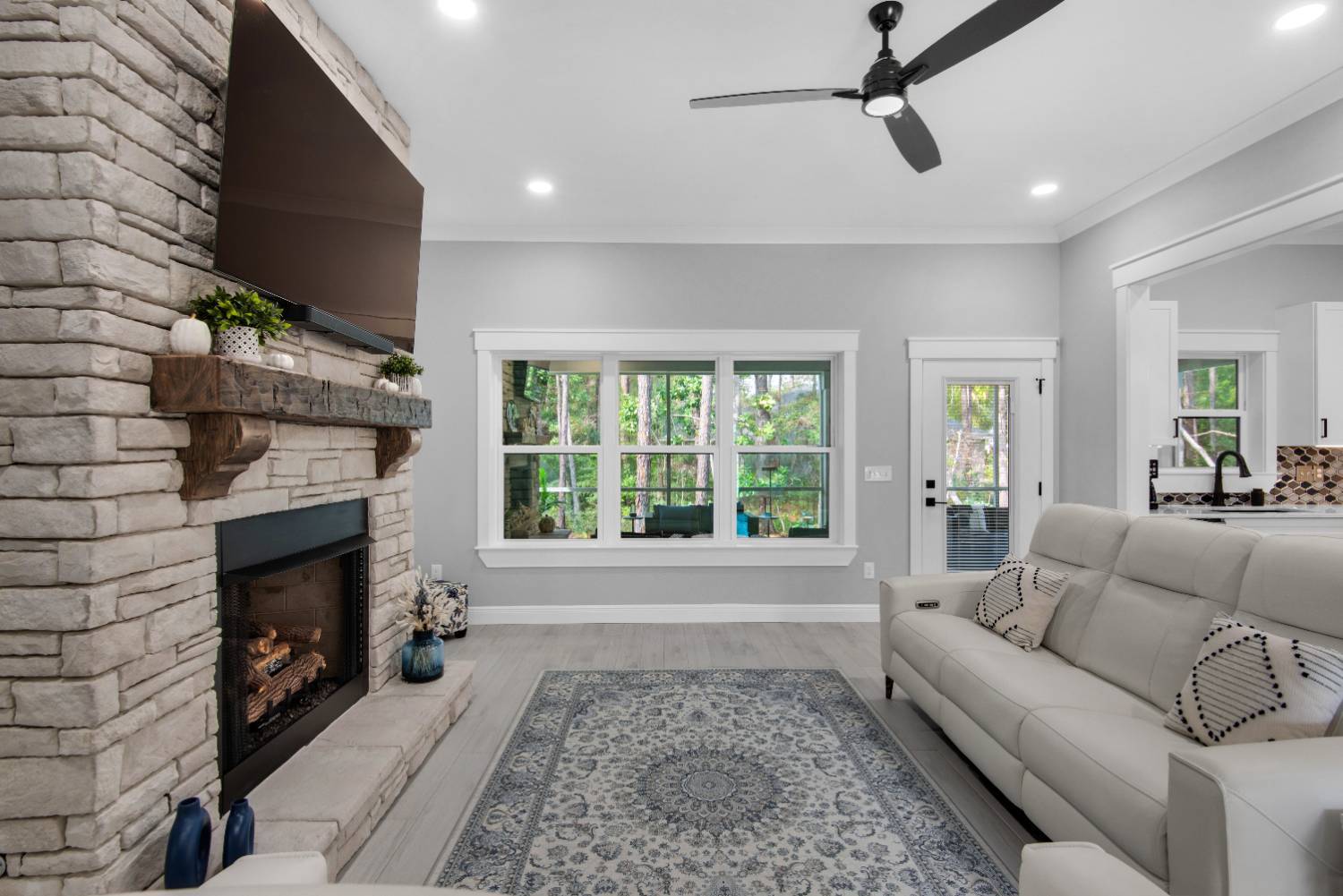 living room angle showing fireplace and large window view by EZ Modern Homes Pensacola FL The Lafon-optimized