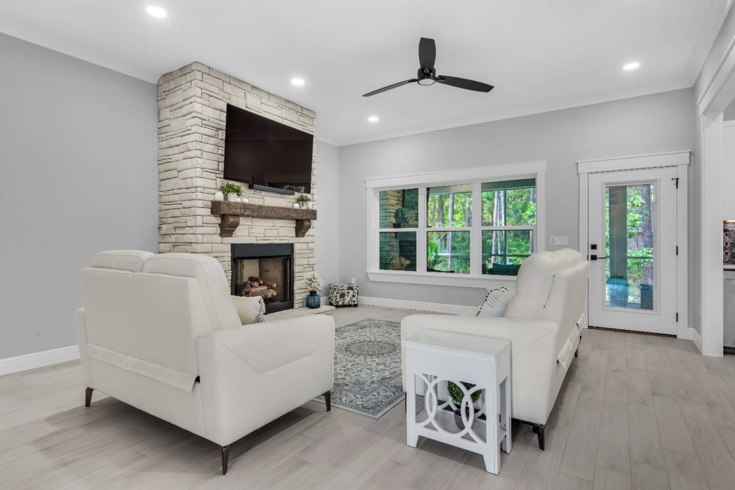 living room with stone fireplace and mounted TV by EZ Modern Homes Pensacola FL The Lafon-optimized